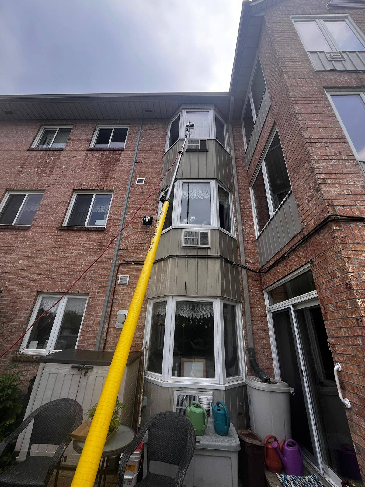 Pole work up the face of a three-storey apartment