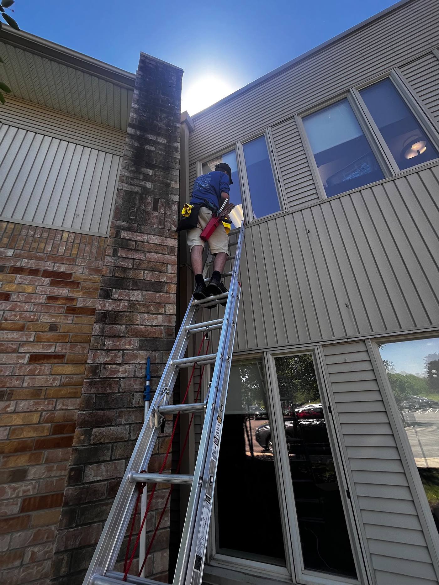 Ladder set against a commercial building to reach upper windows