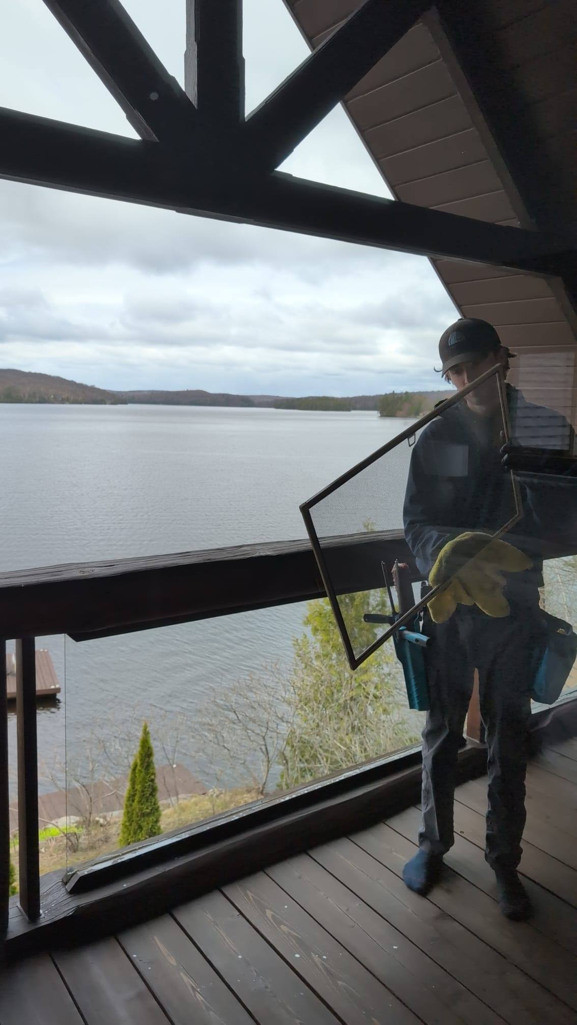 Cottage window being cleaned above the water