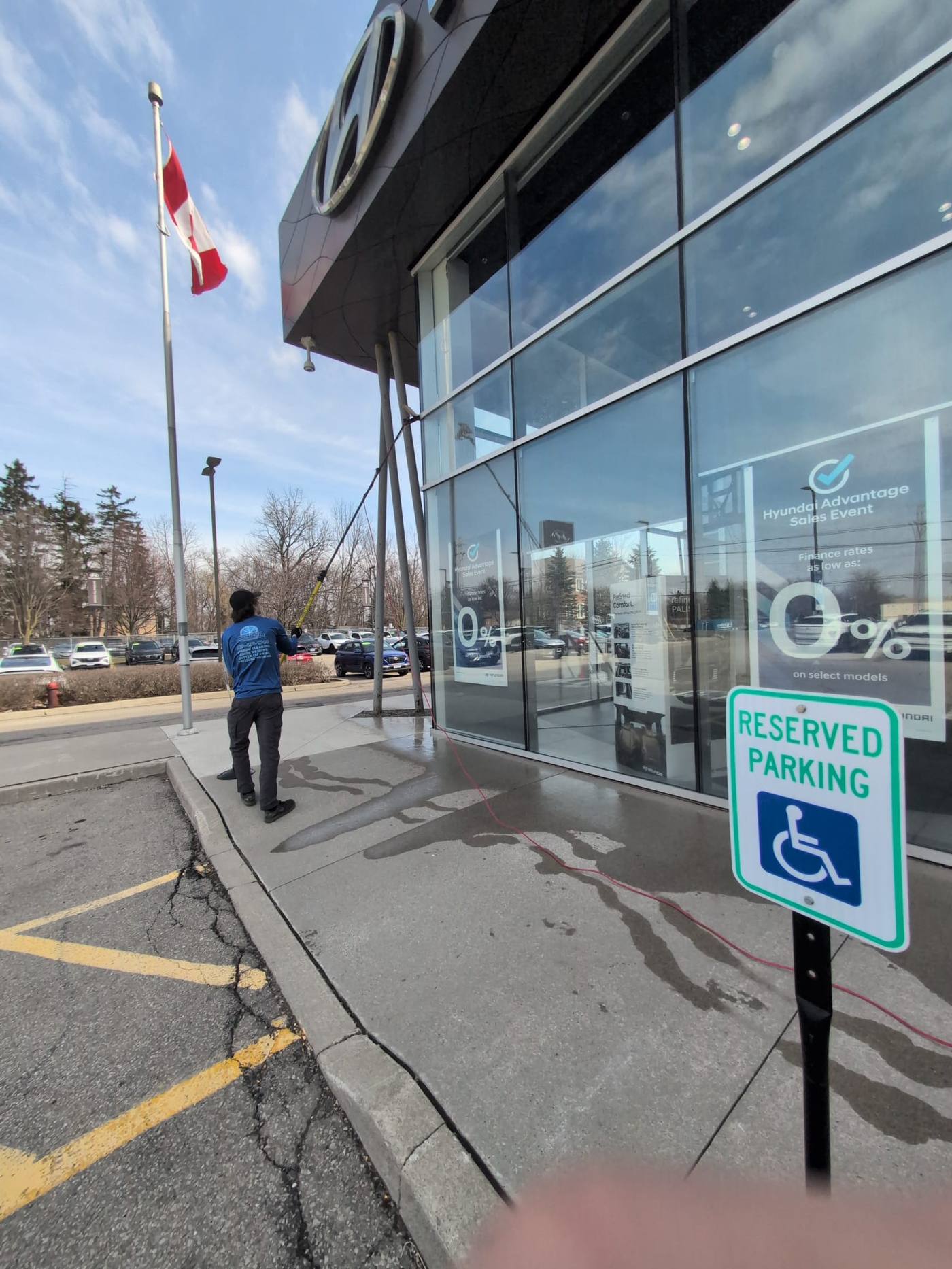 Dealership entrance glass cleaned beside the flagpole
