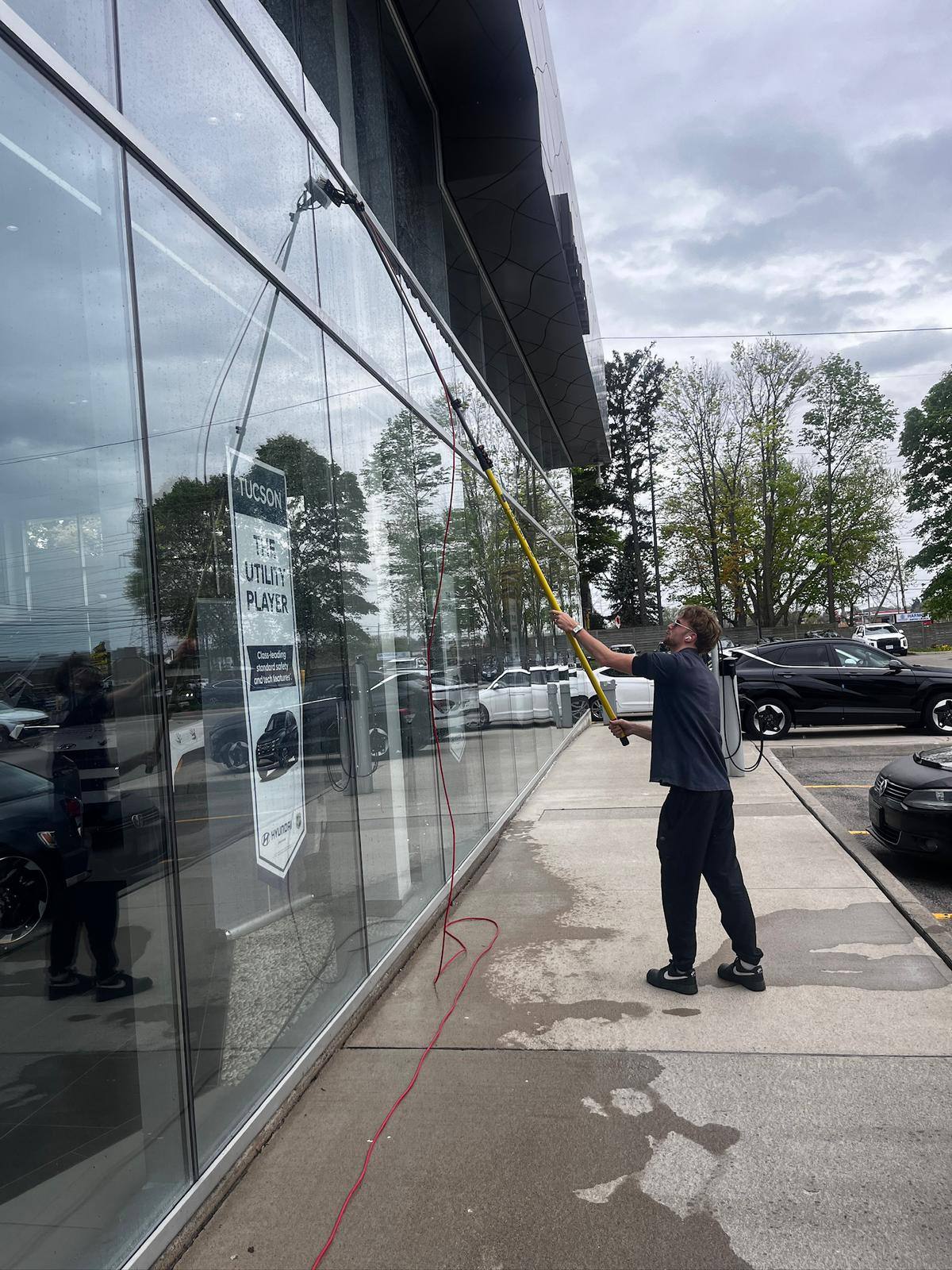 Cleaning the long run of showroom glass at a dealership