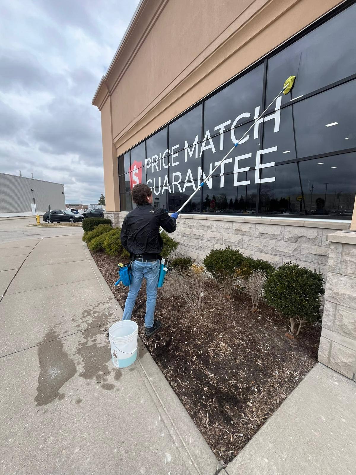 Cleaning storefront windows below the signage